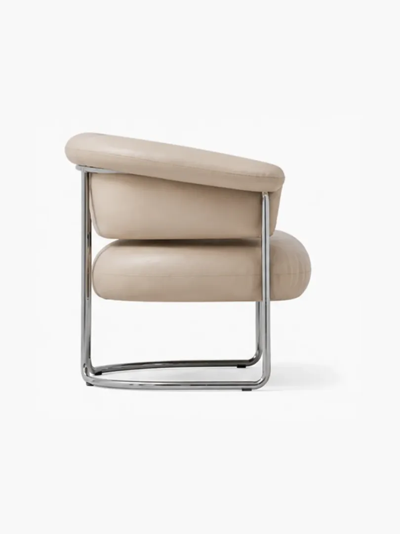 Champagne full grain leather Bauhaus armchair at 45-degree showing seat depth and polished stainless steel floating sled base