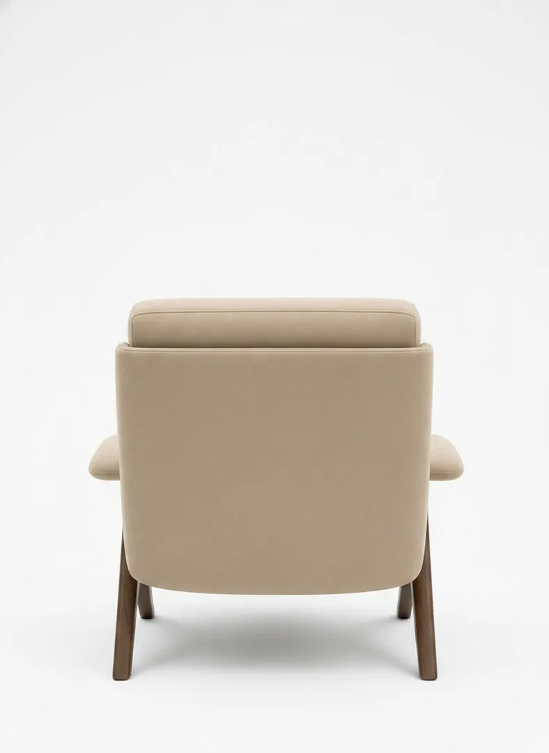 Italian modern walnut armchair back view — layered backrest seam, enveloping bolsters, tapered walnut legs